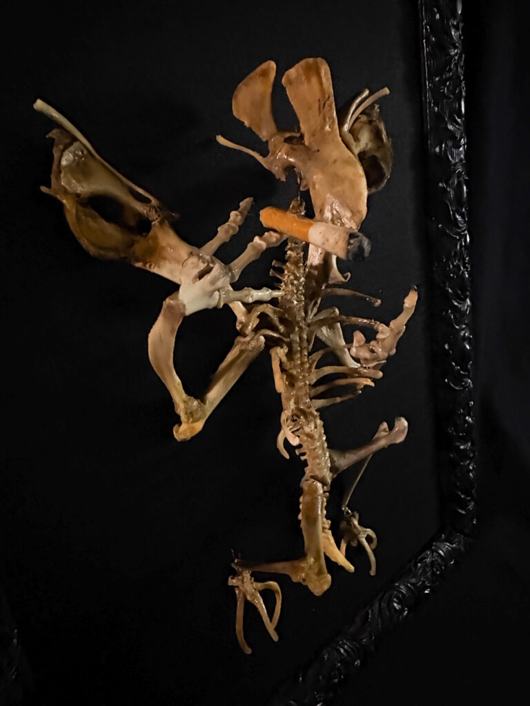 Close-up of the Aillen skeletal sculpture mounted on a charred-wood base, symbolizing the burning of the Hill of Tara.