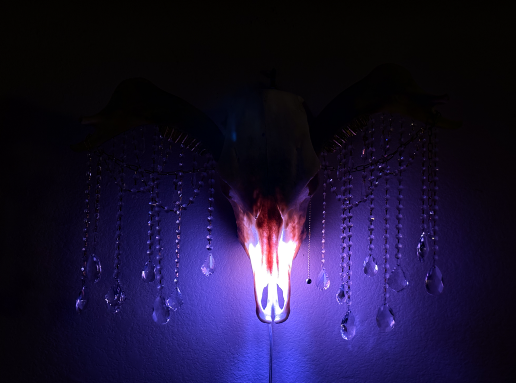 Dramatic low-light silhouette of the Donn Cuailnge skeletal sculpture highlighting the powerful bovine anatomy.